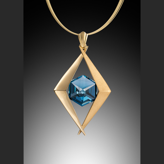 Cave Pendant 18k gold with faceted blue topaz parallelogram